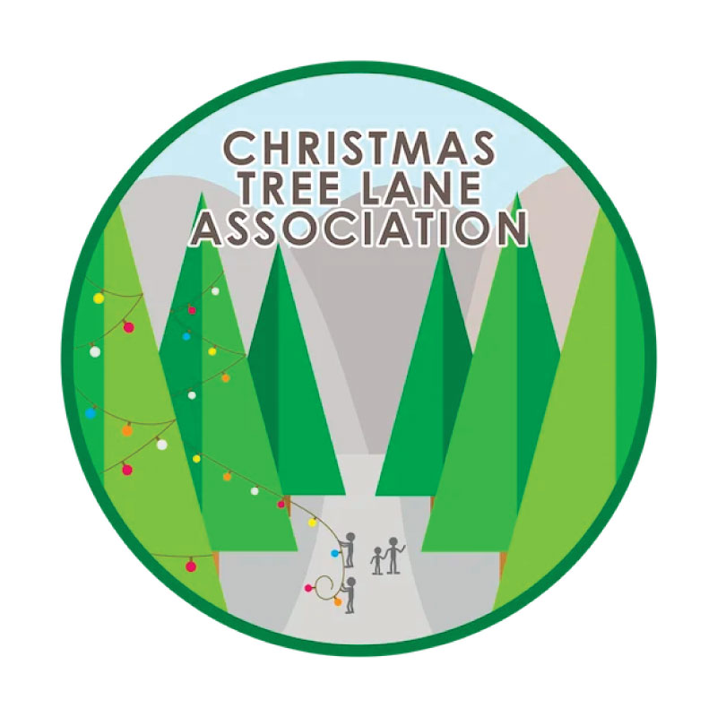 A circular logo with stylized green pine trees, mountains, and a pathway. People decorate the trees with colorful lights. Text at the top reads “Christmas Tree Lane Association.”.