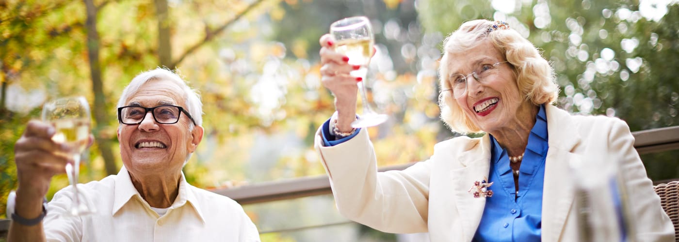 senior couple holding up glass