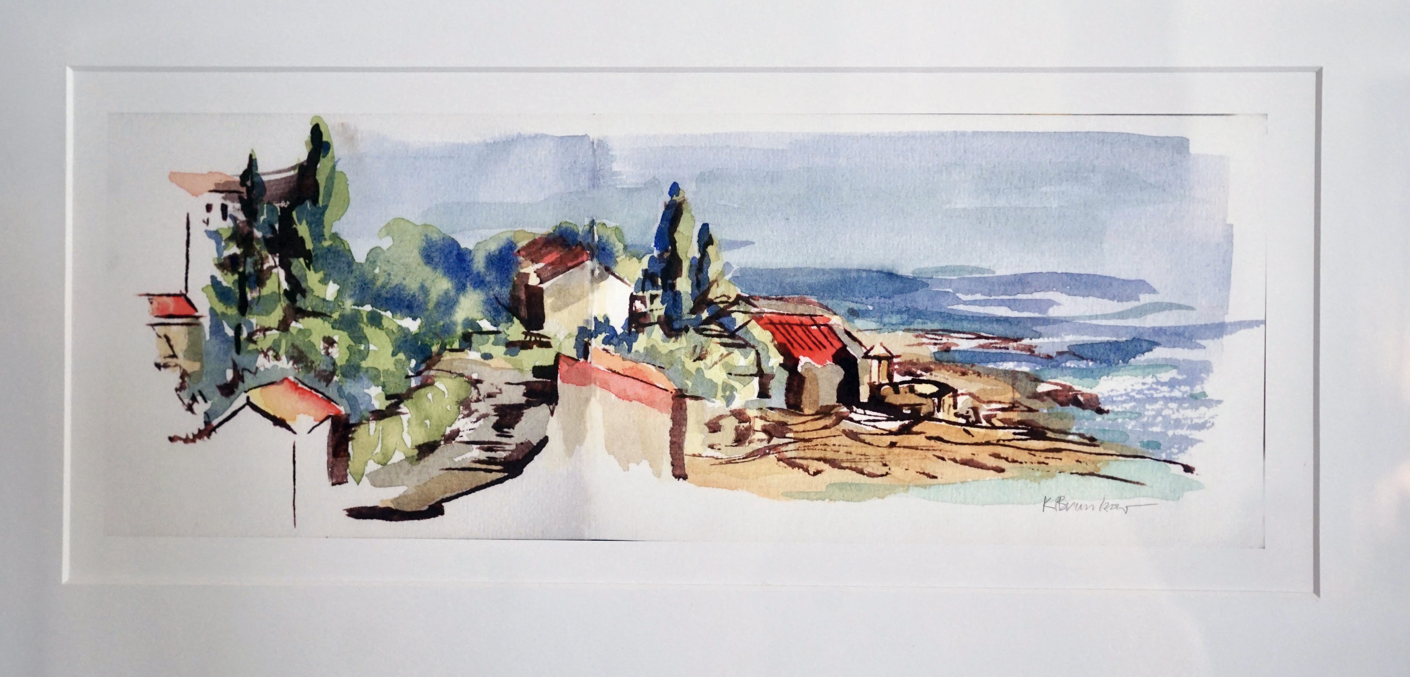 Watercolor painting of a coastal village with red-roofed houses, trees, and a path to the rocky shoreline beside a calm blue sea under a light sky. This artwork showcases creativity and is elegantly framed with a white mat.