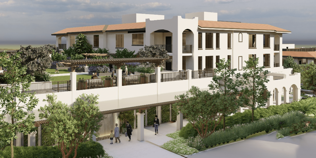 A modern Mediterranean-style building with white stucco walls, terracotta roof tiles, arched entryways, outdoor terraces, and landscaped greenery. Several people walk along a pathway near the entrance.