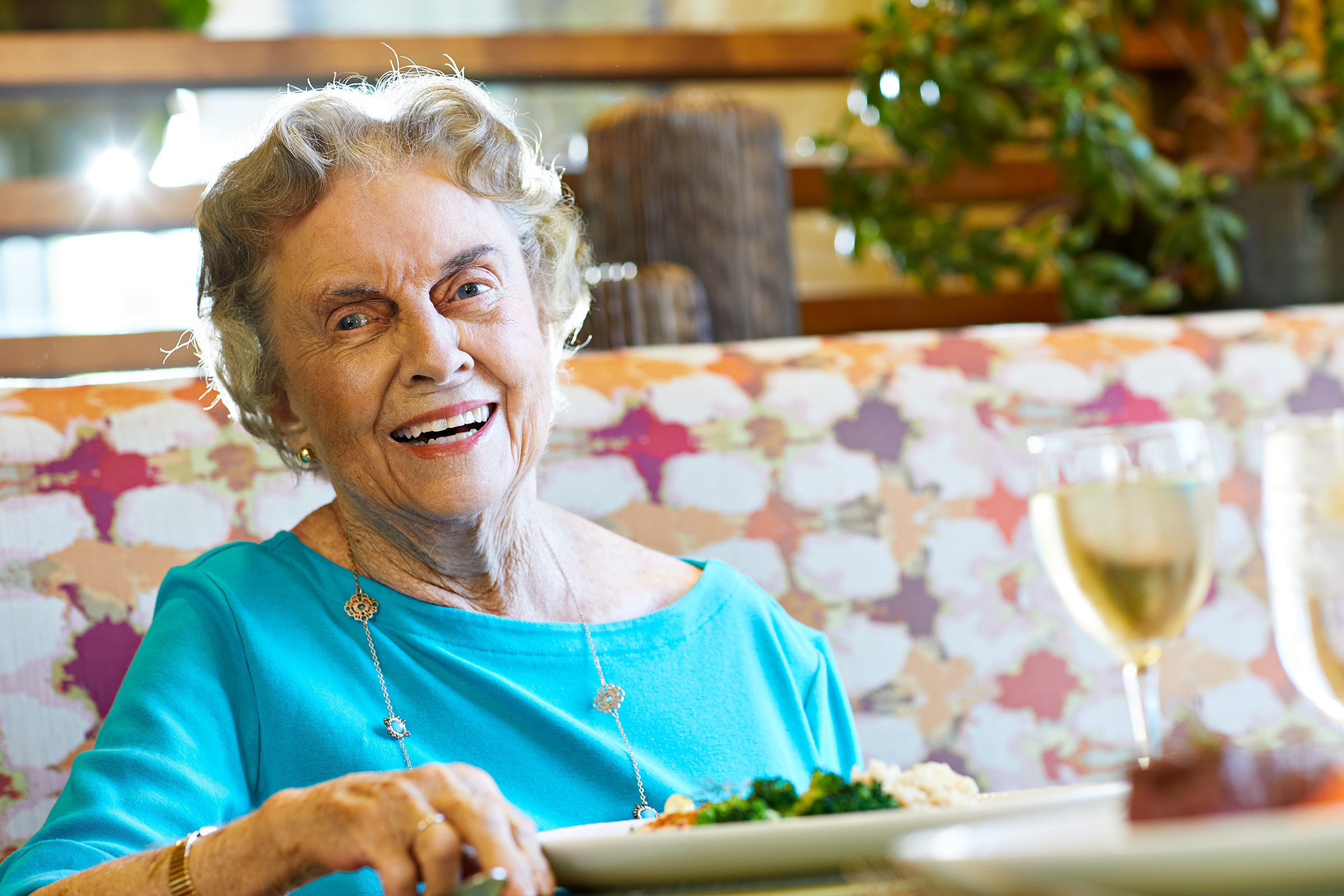 A smiling Covington resident enjoys a meal and luxury assisted living in Orange County.