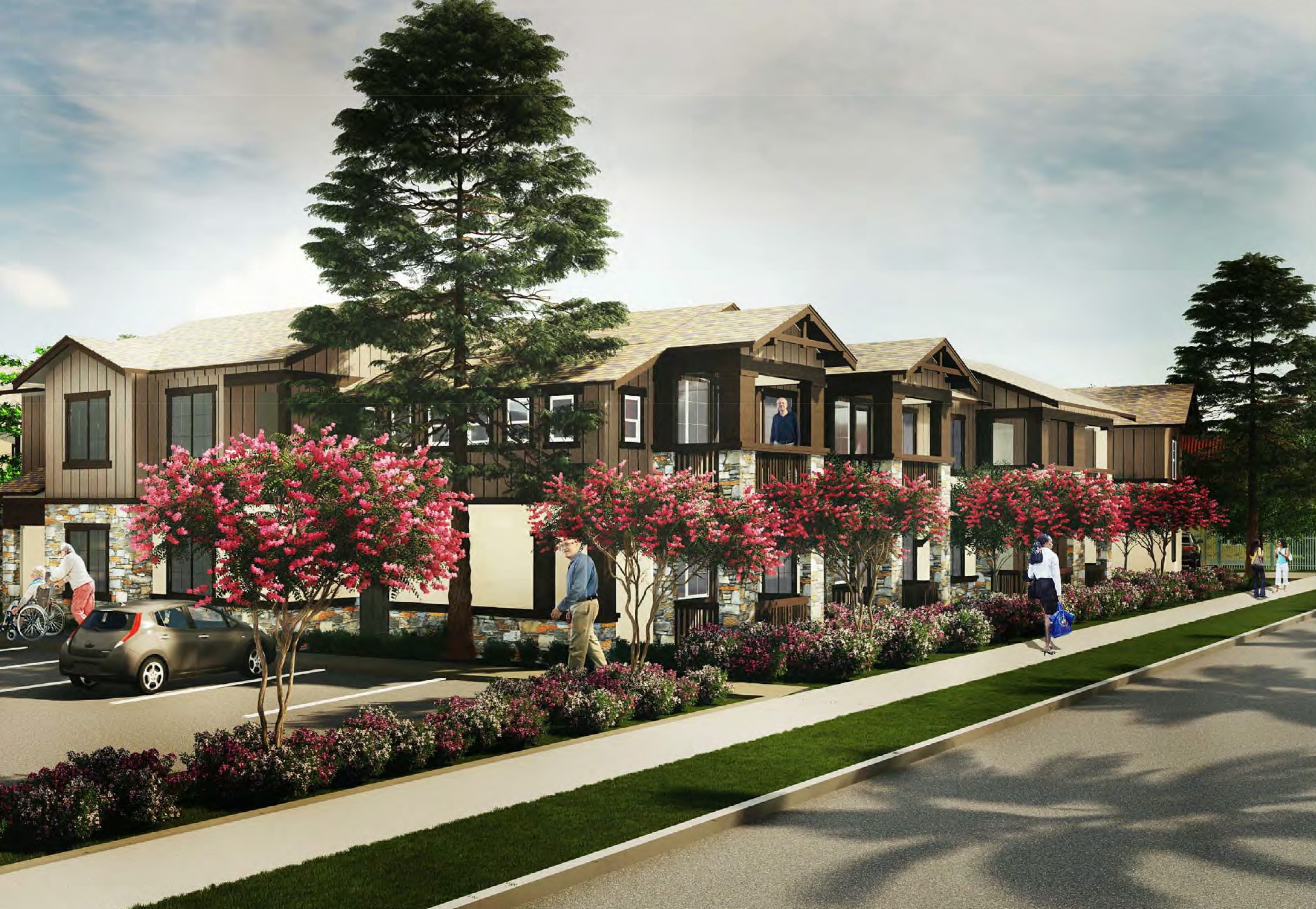 A modern two-story apartment building with wood and stone accents, flowering trees, shrubs, and people walking along a sidewalk. Parked cars and a bicycle are visible in the landscaped parking area.