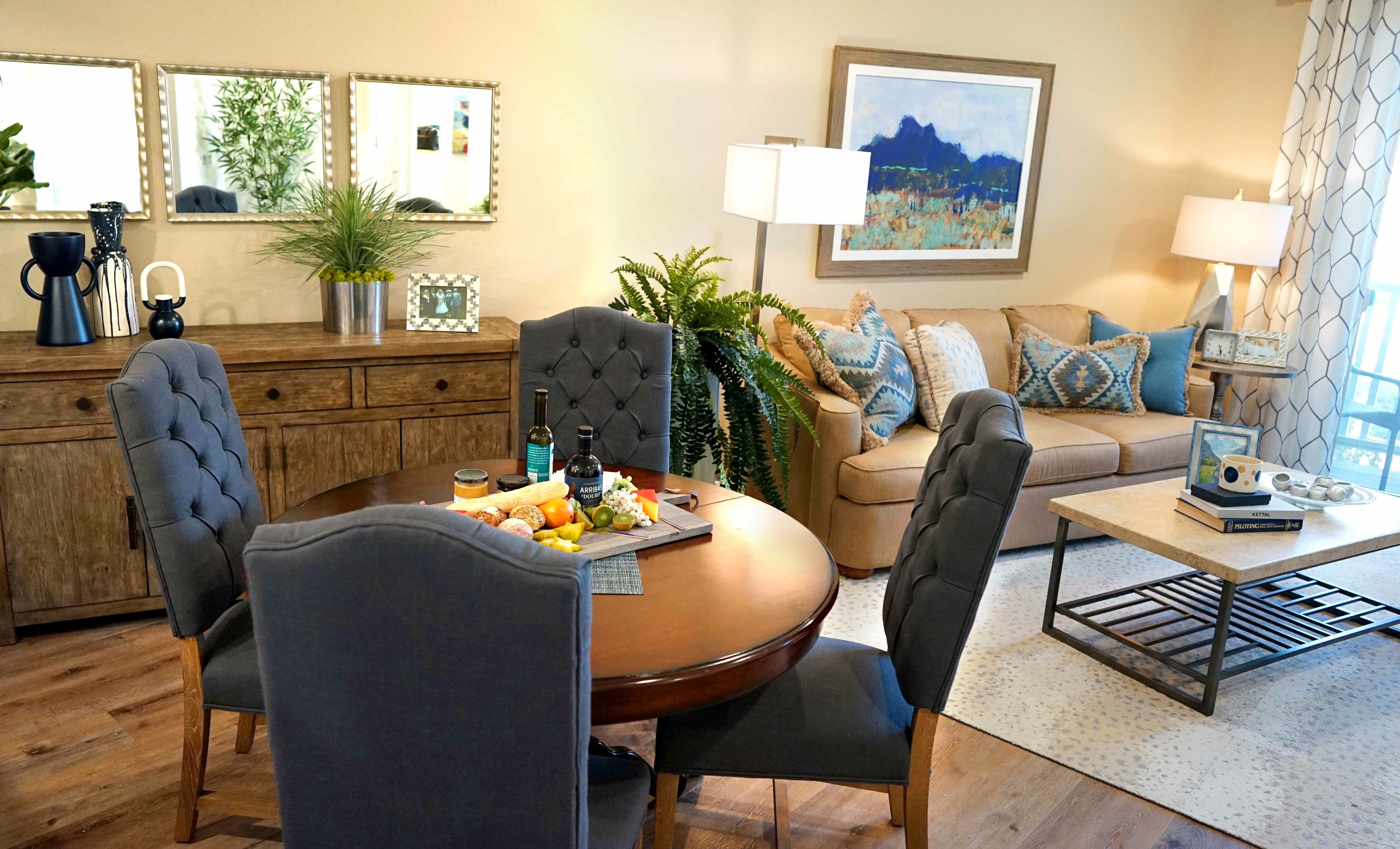 Living room with dining table, chairs, couch, and various plants