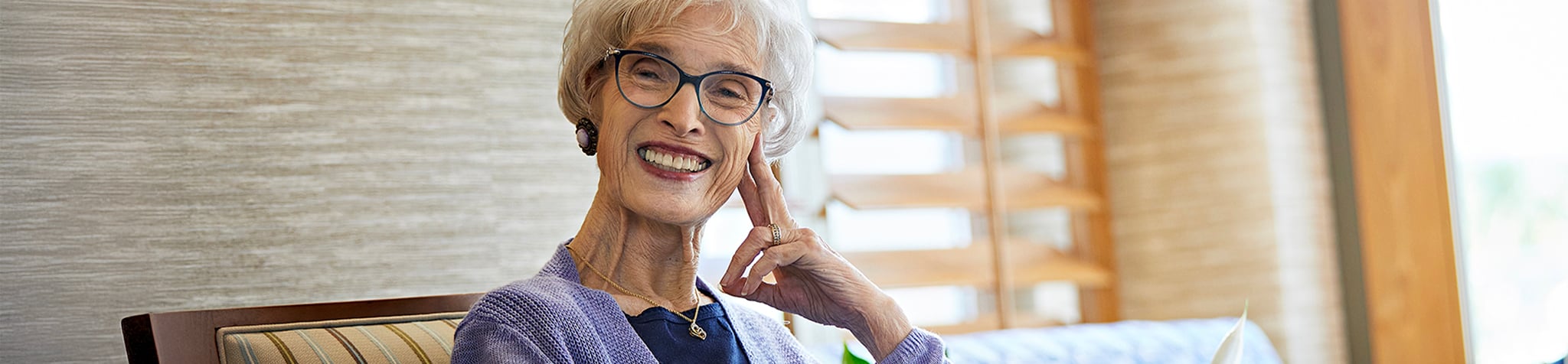 A smiling resident sits inside one of the best retirement communities in Orange County