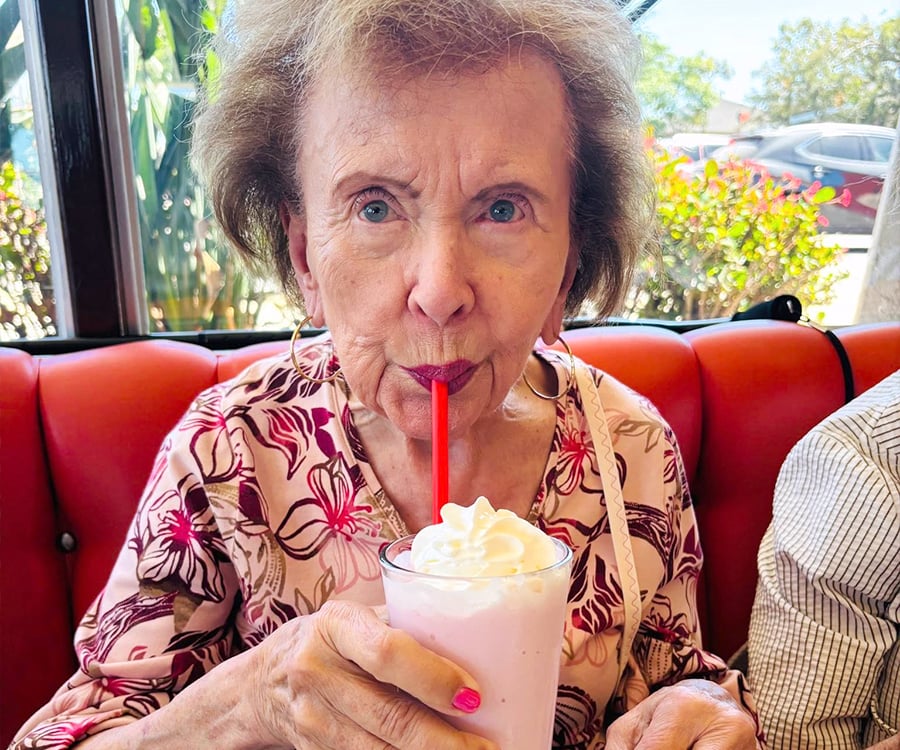 Senior resident enjoying a strawberry milkshake at 50's-themed diner