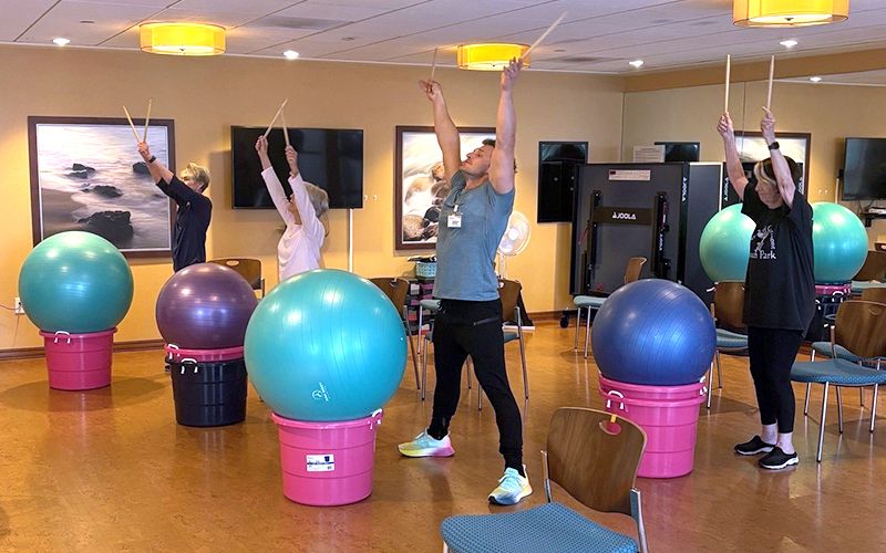 Group of seniors participating in a drumming cardio exercise class.