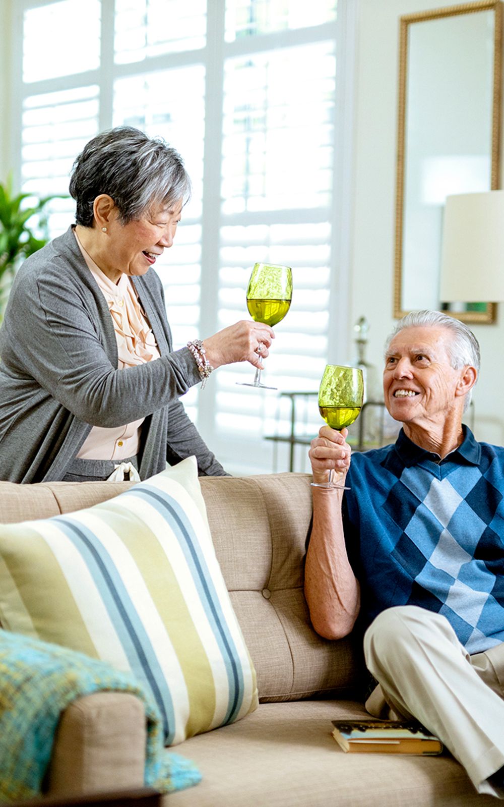 Two senior residents share a glass of wine at a continuing care retirement community