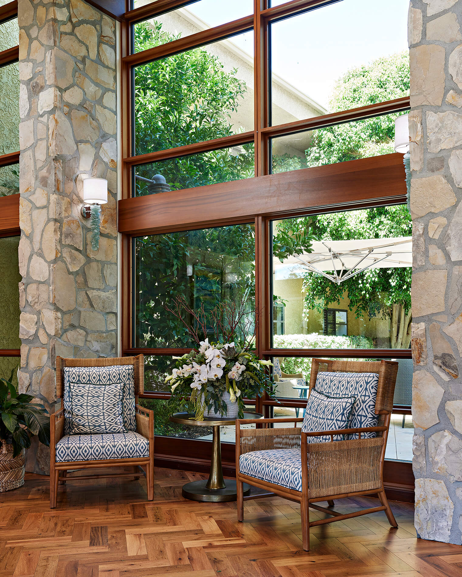 lobby with brick wall, chairs, and table with a plant on it