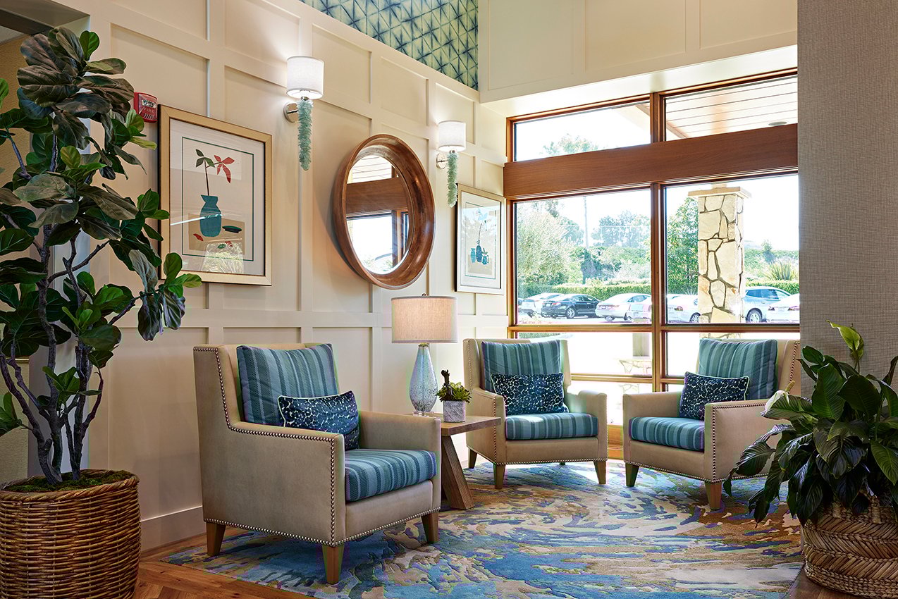 lobby with blue chairs, rug and wallpaper