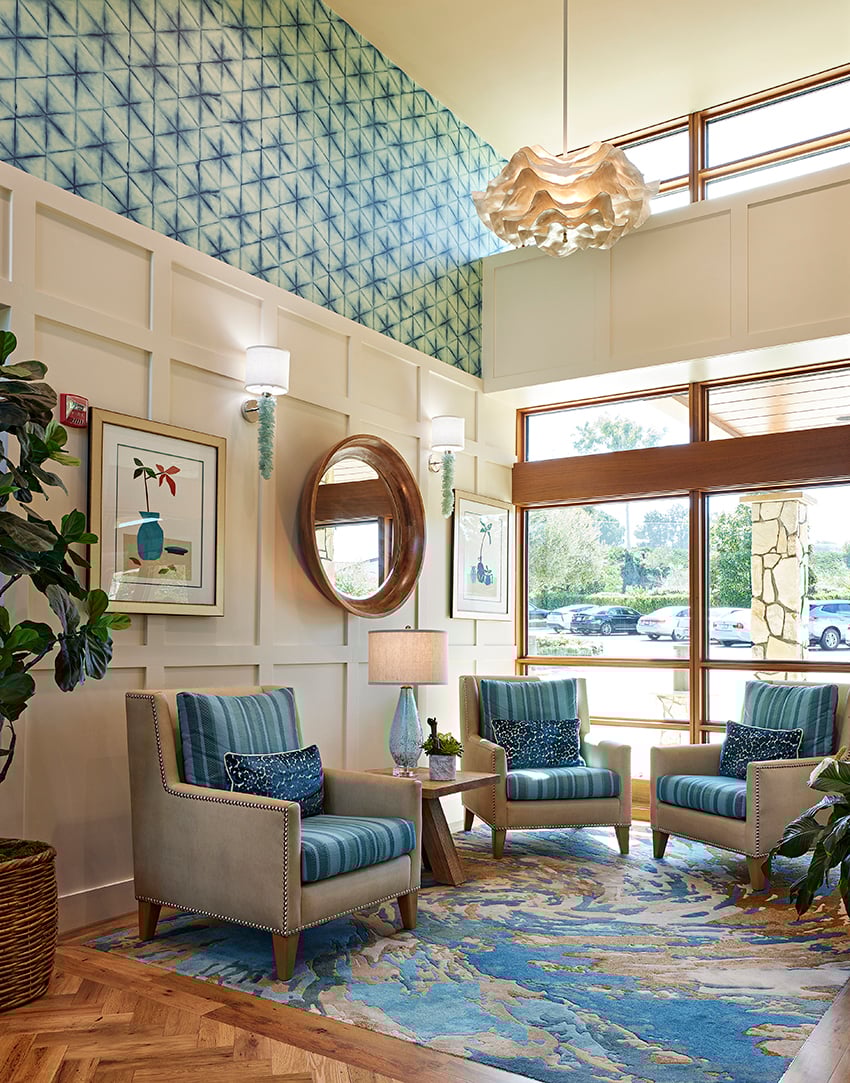 lobby with blue chairs, rug and wallpaper