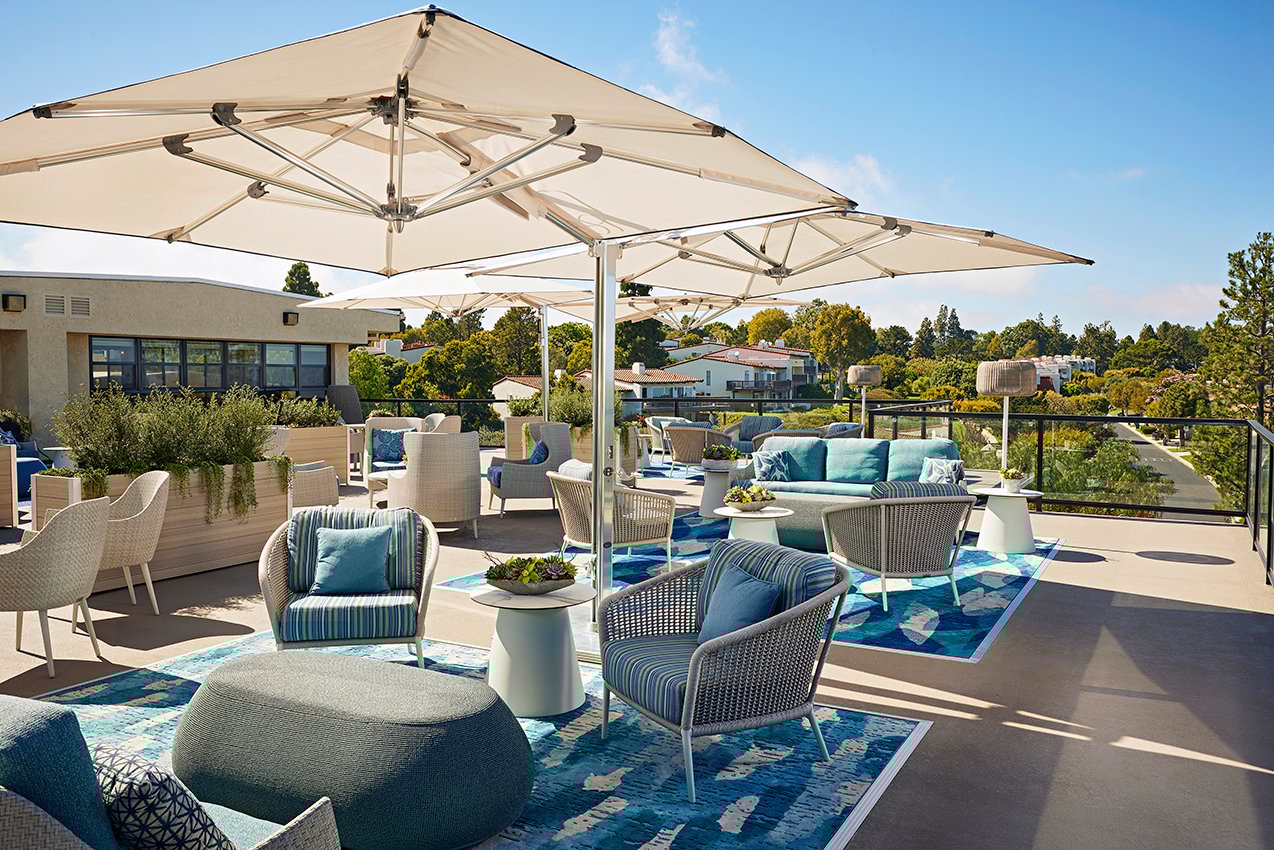 balcony patio with couch, chairs, and tables