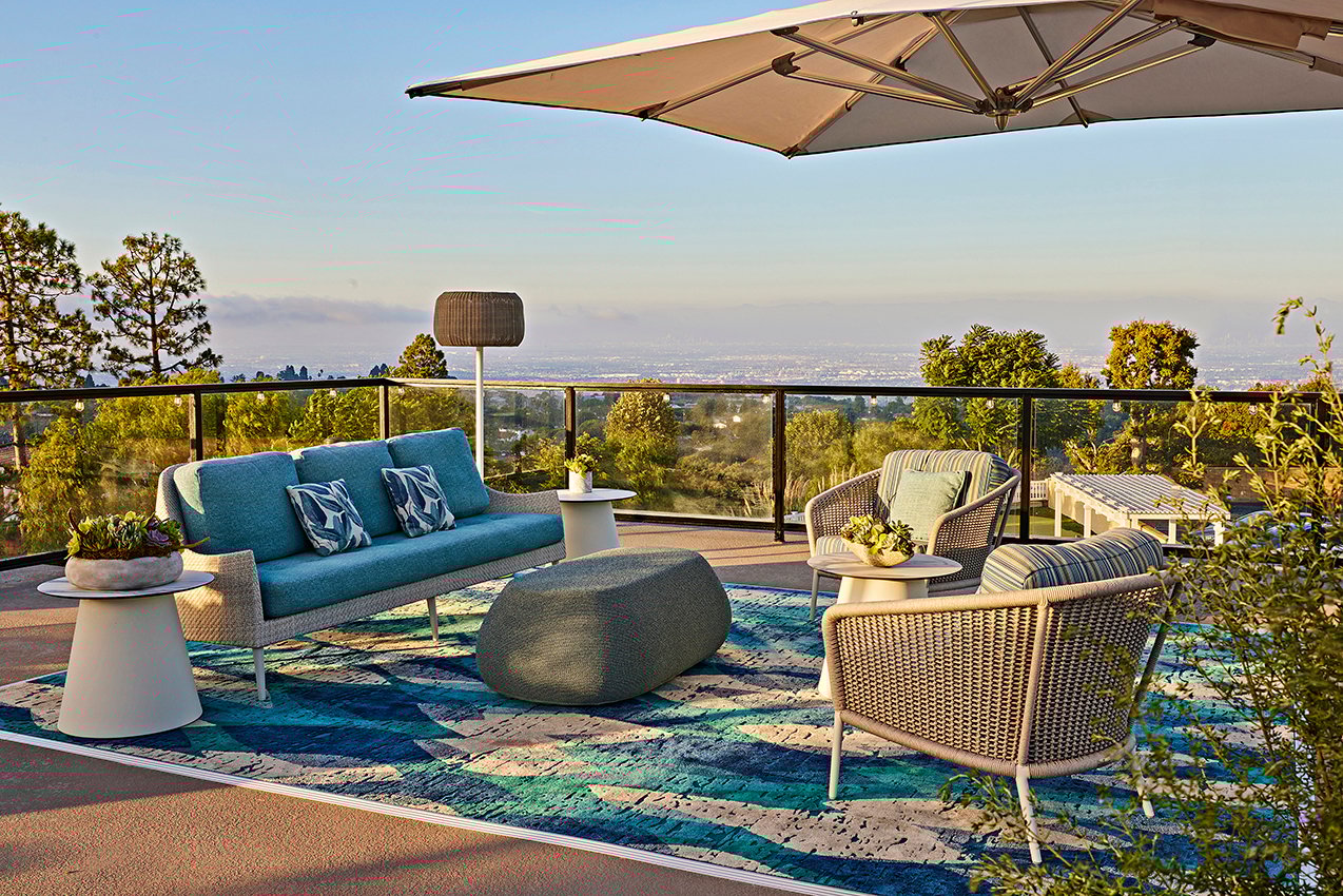 balcony patio with couch, chairs, and tables