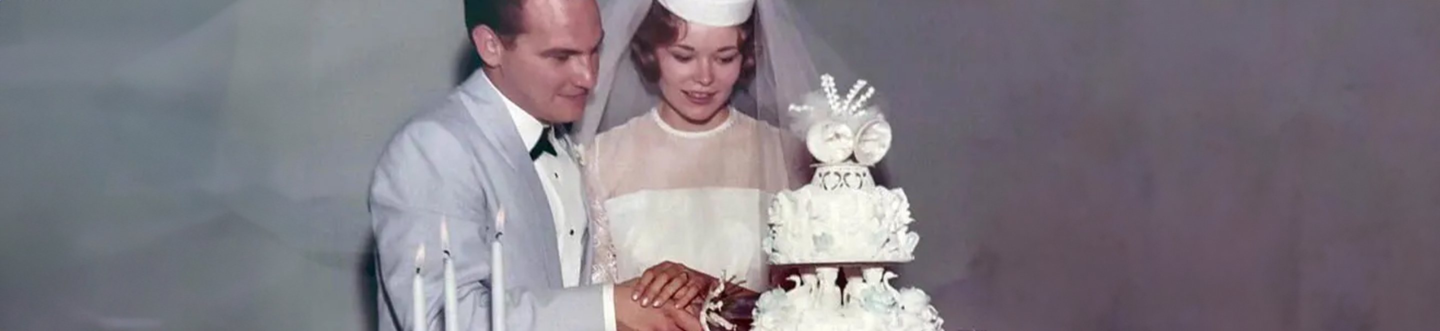 man and woman holding each other next to wedding cake