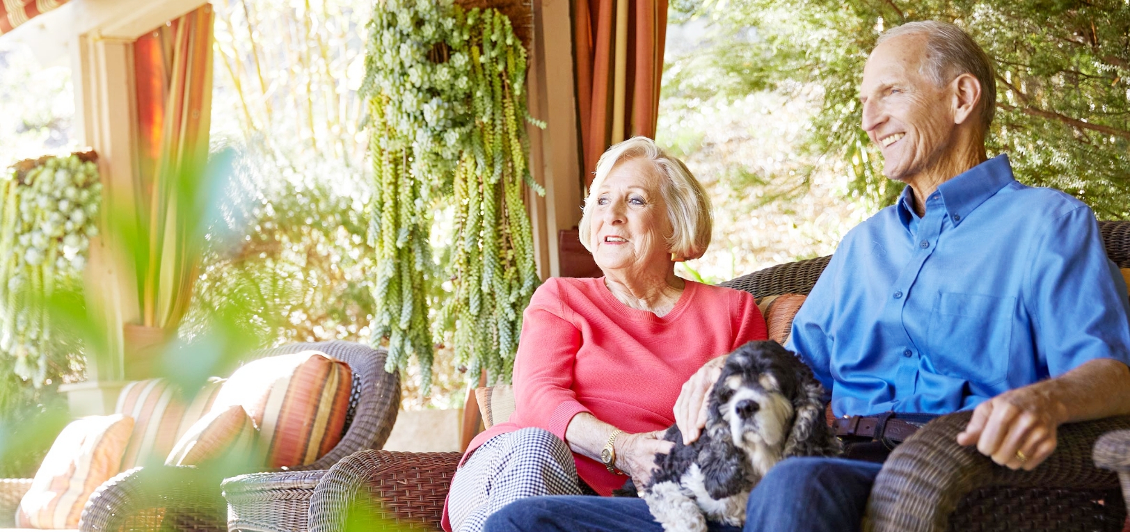 man and woman sitting outdoors with dog