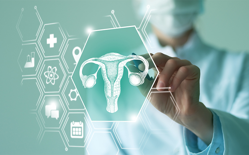 A doctor in a lab coat points at a digital illustration of a uterus on a virtual screen, surrounded by medical and scientific icons.