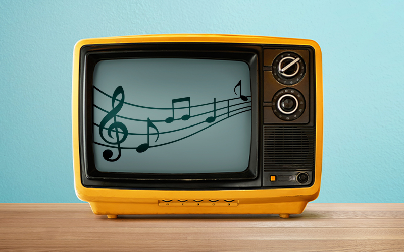 A vintage yellow television sits on a wooden surface, displaying a screen with black musical notes and a treble clef on a blue background.
