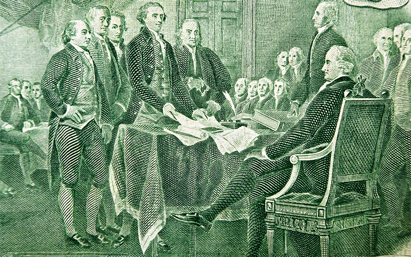 Engraving shows several men in 18th-century attire gathered around a table, signing a document, with one man seated and others standing in a formal room.
